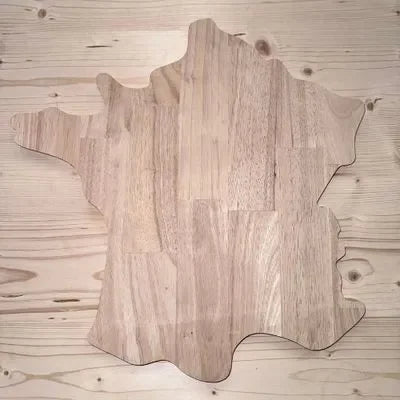 Planche à découper en bois massif en forme de carte de la France sur table claire