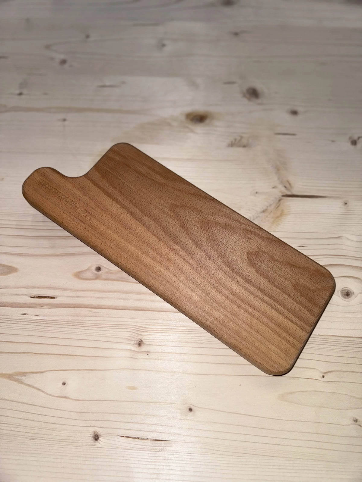 Planche à découper en bois massif rectangulaire sur table en bois clair