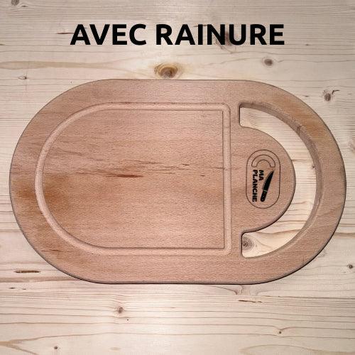 Planche à découper en bois massif avec rainure, forme ovale, posée sur une table en bois.